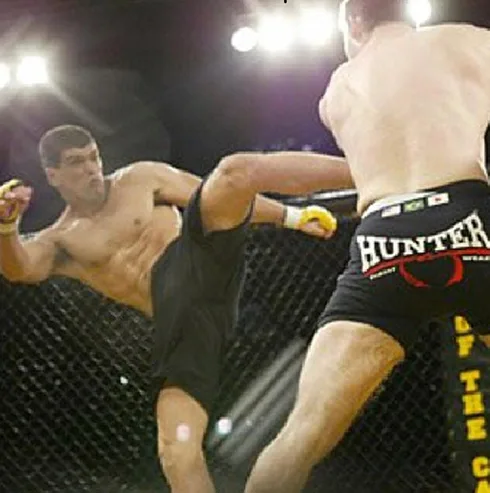 Coach Marcel Ferreira competing in an MMA cage fight during his professional fighting career